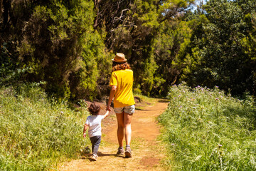 A mother with her son enjoying on the La Llania trekking trail in El Hierro, Canary Islands. lush green landscape