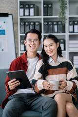 Happy asian young couple smile and looking to screen tablet with laptop at home the morning.
