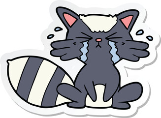 sticker of a cartoon raccoon crying