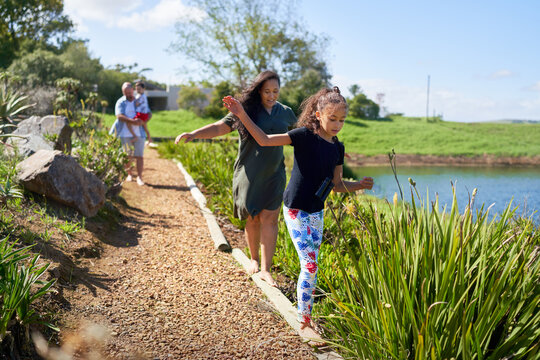 Mother and daughter balancing, walking on footpath logs