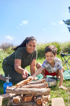 Mother and son with Down Syndrome stacking firewood at campsite