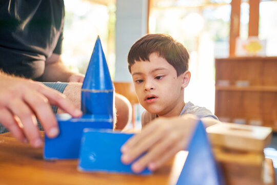 Father and son with Down Syndrome playing with blue block toys
