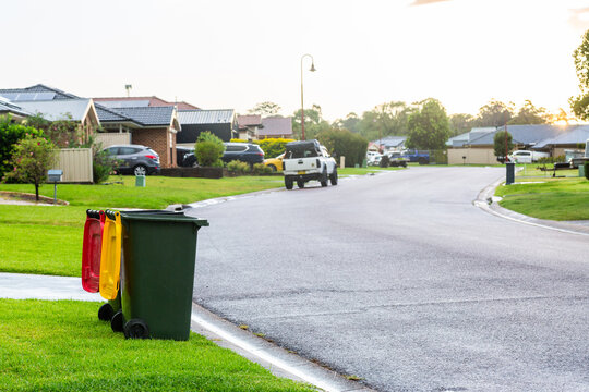 Empty rubbish and recycling bin sitting at bed in suburban road after rain