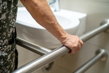 Asian elderly woman patient use toilet bathroom handle security in nursing hospital, healthy strong medical concept.