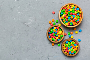 different colored round candy in bowl and jars. Top view of large variety sweets and candies with copy space