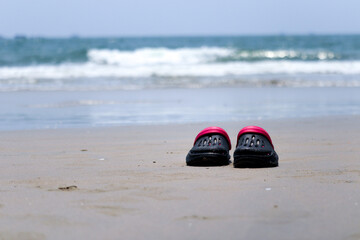 the sneakers or shoes on the beach ocean in the background