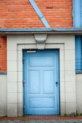 blue blue door in an old brick building. Beautiful pale blue vintage door. Door in an old manufactory