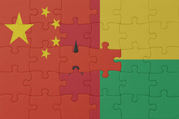 puzzle with the national flag of guinea bissau and china . macro.concept.