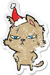 tough hand drawn distressed sticker cartoon of a cat wearing santa hat