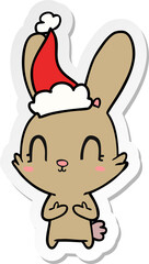 cute hand drawn sticker cartoon of a rabbit wearing santa hat