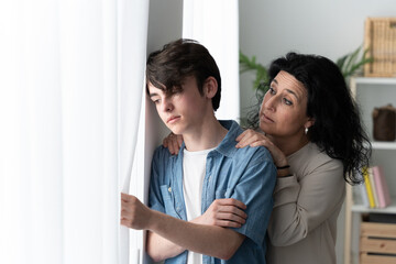 Mother comforting sad teenager son