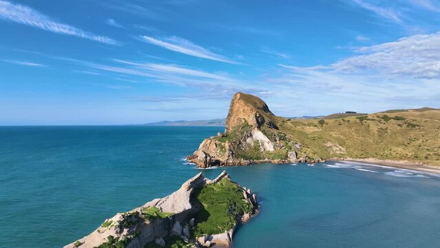 Aerial traverses stunning blue lagoon, reefs, and jagged mountain Aotearoa