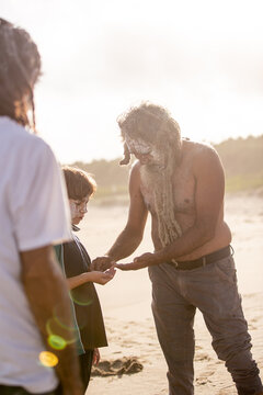 Aboriginal father helping son on a beach
