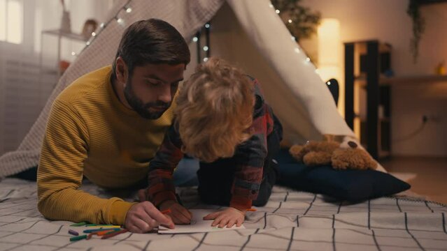 Young father drawing with his little son together, family togetherness, relax