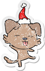 hand drawn distressed sticker cartoon of a dancing dog wearing santa hat