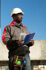 African american worker stands at construction site with work papers