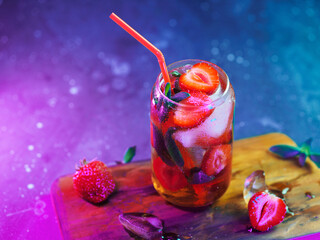summer strawberry lemonade with soda and mint. strawberry cocktail. colored light