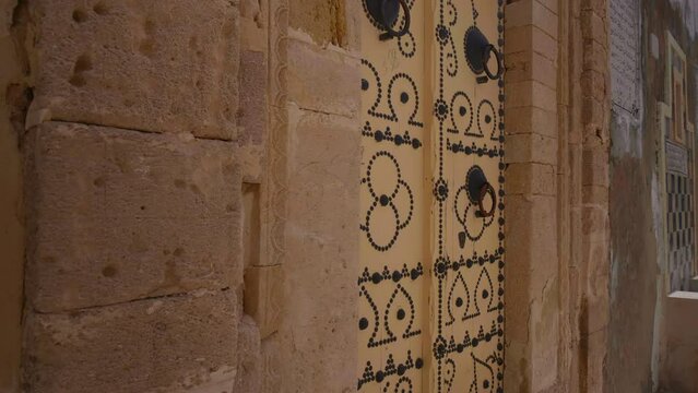 Richly decorated door frame with yellow door in Sousse. Old wooden door in old Sousse, Tunisia.