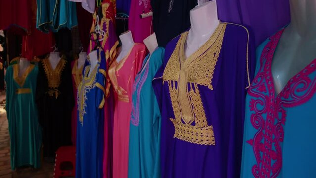 Stall selling colorful traditional clothing with fine embroidery in the old town of Sousse. Street market with clothes specific to Tunisia.