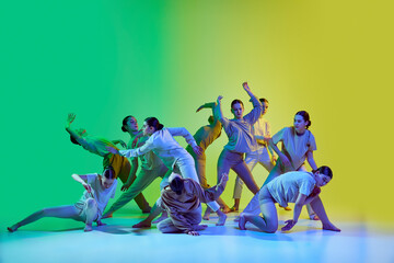 Group of young people dancing contemp against green and yellow gradient background in neon light. Diversity, chaos and freedom