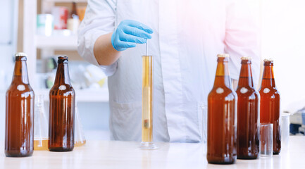 Laboratory assistant inspecting production beer, analysis drink in glasses. Concept brewery food industry