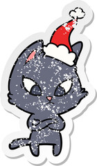 confused hand drawn distressed sticker cartoon of a cat wearing santa hat
