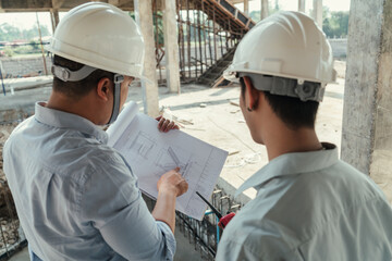 Civil engineer team meeting, discussing plan construction in blueprint at construction site.