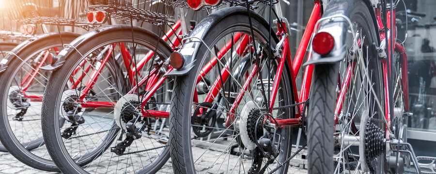 Closeup view many red city bikes parked in row at european city street rental parking sharing station or sale. Healthy ecology urban transportation. Sport environmental transport infrastructure