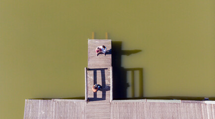 Overhead shot of mother and son sitting on lakeside deck