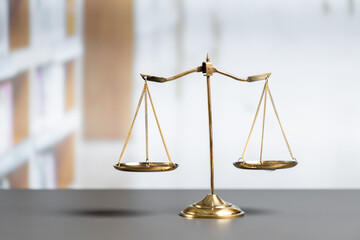 Shiny golden balanced scale in court library background as concept justice and fairness legal...