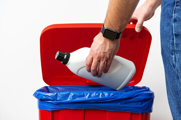 A man throws garbage into the trash can close up