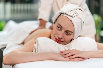 Fototapeta na wymiar Beautiful caucasian woman laying for masseuse to massage oil, nourish skin and relax in spa wellness.