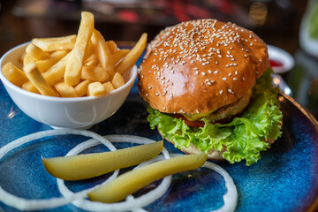Pork Hamburger with Lettuce and French Fries in a restaurant. It's junk food, it's lunch 