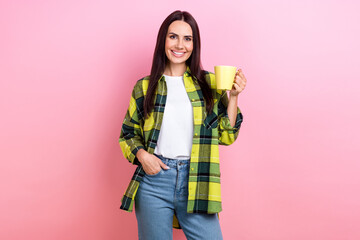 Photo of lovely nice girl with straight hairstyle wear checkered shirt arm in pocket hold mug of coffee isolated on pink color background