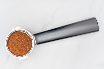 Coffee cone with ground coffee lie on marble table.