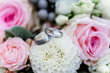 Silberne Ringe auf weißer Blume im Brautstrauß