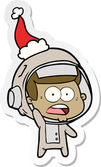hand drawn sticker cartoon of a surprised astronaut wearing santa hat