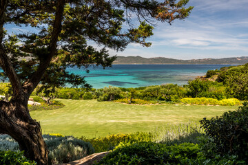 Turquoise water and green coastline of a luxury summer destination in Costa Smeralda, Sardinia, Italy. Wide angle view