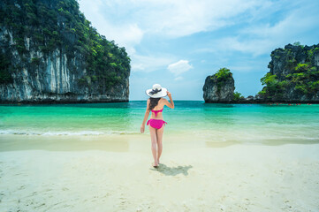 Female tourist wearing bikini on white beach tea, blue green water at Maya Bay, Koh Phi Phi