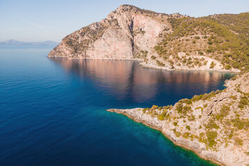 Winding coastline of Aegean seacoast with calm turquoise water in sunny day. Aerial view