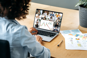 Online video conference. Over shoulder view of african american business woman, at laptop screen...