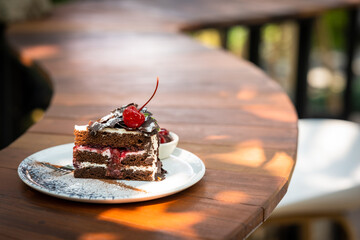 Plate with slice of tasty homemade chocolate cake on table