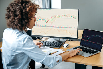 Successful busy african american female trader, stock investor, broker, financial expert, sit at...