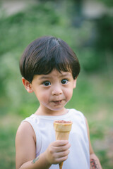 Asia boy he mouth aftertaste from eating chocolate ice cream  or chocolate dessert. A sweet-toothed child eat chocolate.