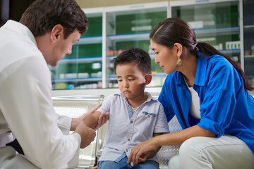 Surgeon palpating arm of little boy checking of fracture healed