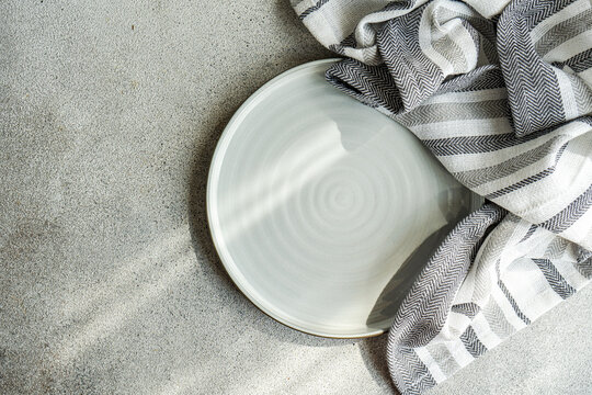Overhead view of a ceramic plate with a striped tea towel