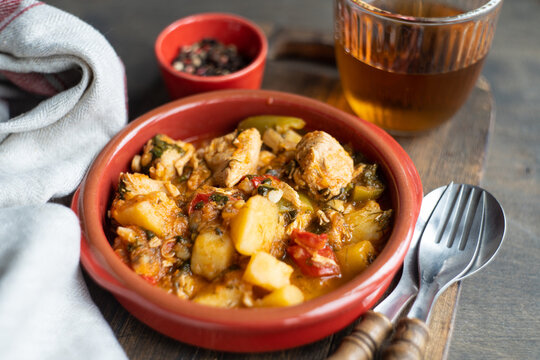 Chicken stew with vegetables and a glass of orange wine