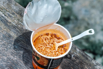 Instant spicy noodle in plastic cup. Closeup top view noodle fast food.