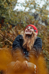 A happy young woman enjoying a view of nature in an autumn forest.Autumn,travel,outdoor adventure,slow life concept.