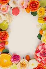 Decoration frame with flowers roses, peonies, lime, macarons, kumquat, oranges on a white background. Pink, orange, green violet, purple, yellow petals. Cover for desert culinary book, poster, greet